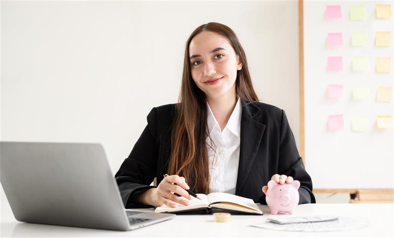 Law student at laptop with piggy bank