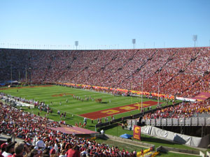 The USC stadium is packed with fans wearing red or white shirts.