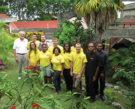 A group of people pose outdoors. Several of them are wearing yellow T-shirts.