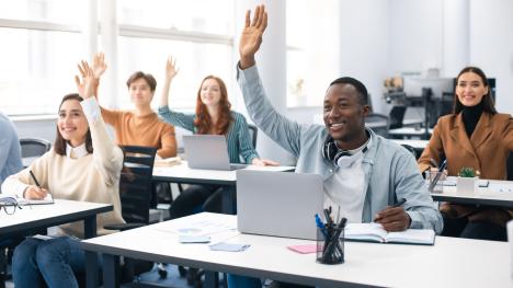 Law students in lecture hall raising hands