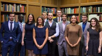 Group of law students in front of law library bookshelves.